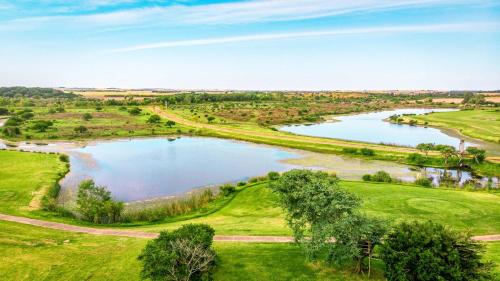 an aerial view of a lake on a golf course at La Casa de Cristal by Puerto Dijama in Carmelo