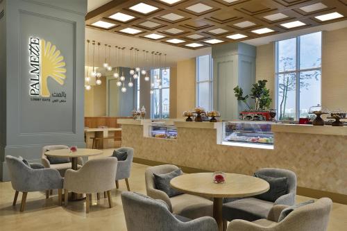 a waiting room with two tables and chairs at Hilton Al Khobar King Fahd Causeway in Al Khobar