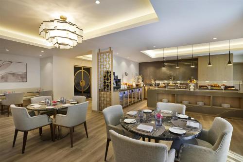 a dining room with a table and chairs and a kitchen at Hilton Al Khobar King Fahd Causeway in Al Khobar