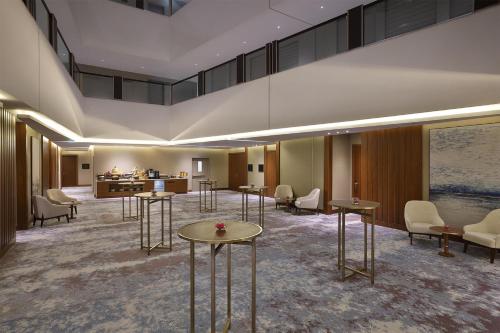 a lobby of a hotel with tables and chairs at Hilton Al Khobar King Fahd Causeway in Al Khobar