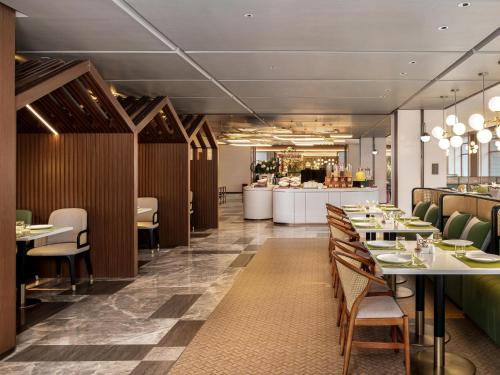 a restaurant with tables and chairs and a bar at Hilton Garden Inn Zhangjiajie Wulingyuan in Zhangjiajie