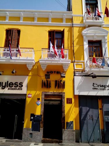a yellow building with flags on the balconies at Hotel Inka Path in Lima