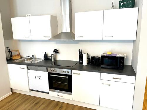 a kitchen with white cabinets and a microwave at Dresden Frauenkirche 8 Personen in Dresden