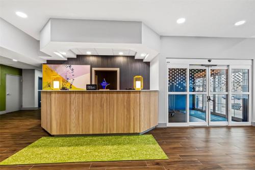 an office lobby with a reception desk and large windows at Spark by Hilton Wilkes Barre in Wilkes-Barre