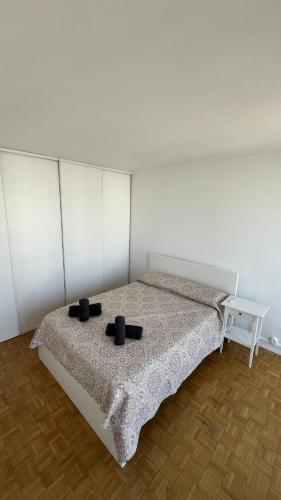 - une chambre avec un lit doté de 2 oreillers noirs dans l'établissement Choisy Royal Séjour, à Choisy-le-Roi