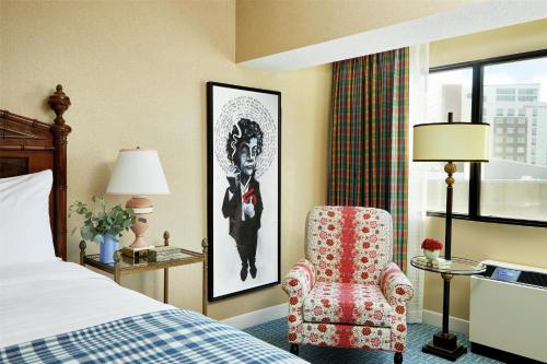 a bedroom with a bed and a chair and a window at Graduate by Hilton Iowa City in Iowa City