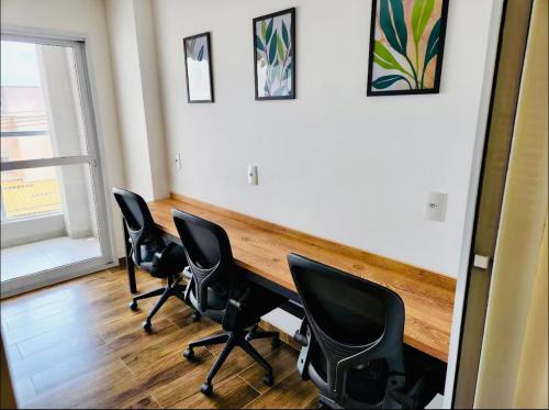 a room with four chairs and a wooden table at Studio Home 64 Luxo in Mogi das Cruzes