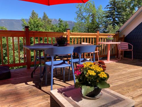 a deck with a table and chairs and a vase of flowers at Historic Glacier Getaway with Spectacular Views-20mins to Glacier National Park-10mins to airport and walkable to downtown! in Columbia Falls