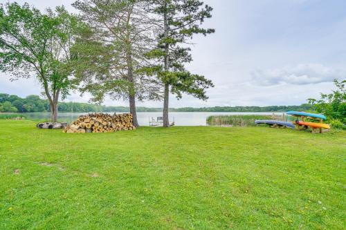 a field of grass with a boat on a lake at Snowmobile Trail On-Site Waterfront Mound Gem! in Mound