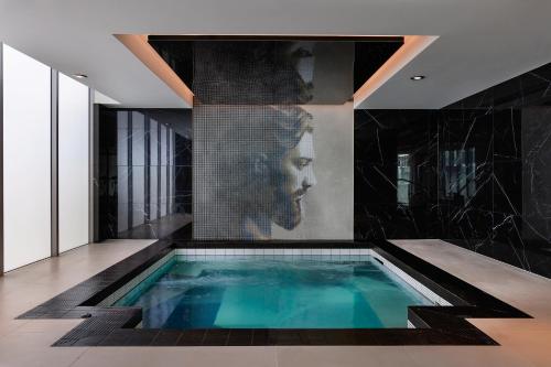 a bathroom with a swimming pool with a painting on the wall at Marsden Viaduct in Auckland