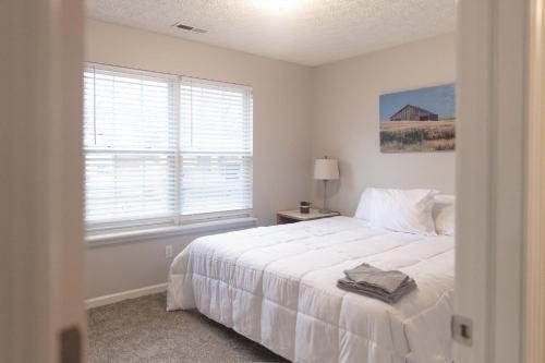 a white bedroom with a bed and a window at Mins to Park River Downtown Chapel Hill Charmer in Indianapolis