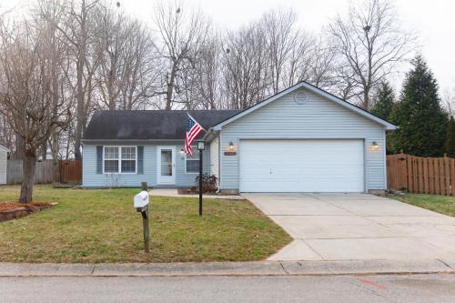 a blue house with an american flag in the yard at Mins to Park River Downtown Chapel Hill Charmer in Indianapolis