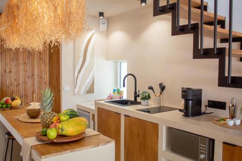 - une cuisine avec une corbeille de fruits sur un comptoir dans l'établissement Casa Maleïwa, à Roissy-en-Brie