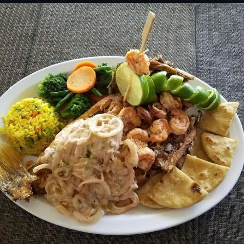 a plate of food with shrimp and chips and rice at Hotel Casa Miramar in Tamanique