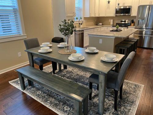 a kitchen with a wooden table with chairs and a dining room at Mins to Downtown & Raceway Rookwood Retreat 2 in Indianapolis