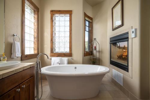 Un baño grande con una bañera grande y un televisor. en Base Camp 490 Private Hot Tub, en Winter Park