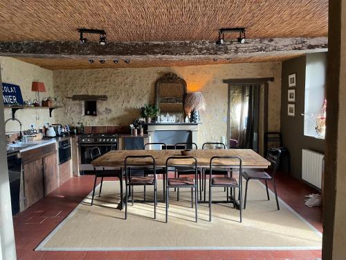 une cuisine avec une table et des chaises en bois dans l'établissement Authentique maison de famille, à Val-au-Perche