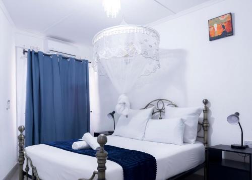 a bedroom with a bed and a chandelier at Magodi Place - Serviced & Airconditioned Apartment in Livingstone