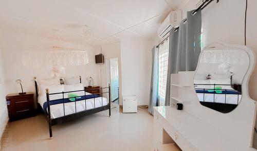two beds in a room with white walls at Magodi Place - Serviced & Airconditioned Apartment in Livingstone