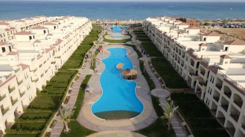 an aerial view of a resort with swimming pools at Lasirina palm beach for families only in Ain Sokhna