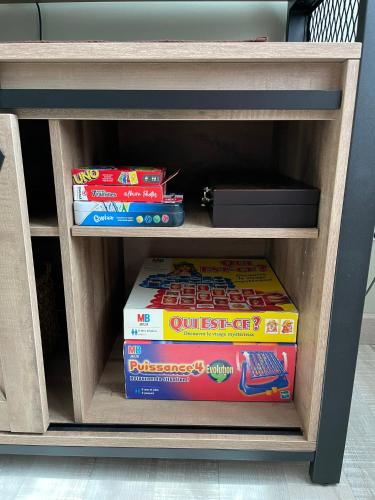a book shelf with a stack of games at Le Colibri in Vinneuf