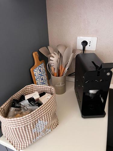 a counter with a basket of utensils and a printer at Relais Macramè in Manfredonia