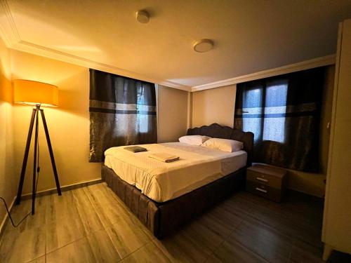 a bedroom with a bed and a lamp in it at Müstakil Alt Kat Havuzlu Villa in Mersin