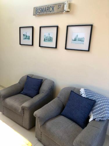 a living room with two couches and pictures on the wall at Bismarck 2 in Swakopmund