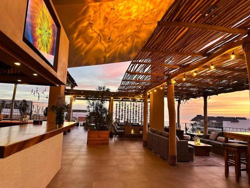 a restaurant with a bar with a view of the ocean at Beach Loft LIFE Bucerías - Zona Dorada in Bucerías