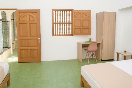 a bedroom with a bed and a desk and a door at SGH Hotel San Agustin in Santa Marta