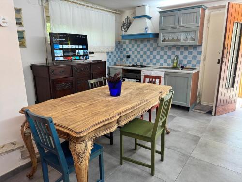 a kitchen with a wooden dining table and chairs at Ottocento - Casa Brunori in Follonica