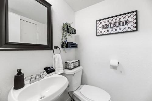 a bathroom with a toilet and a sink and a mirror at Dome Manor 2 Game Rooms, Hot Tub & Pool! in Bedford