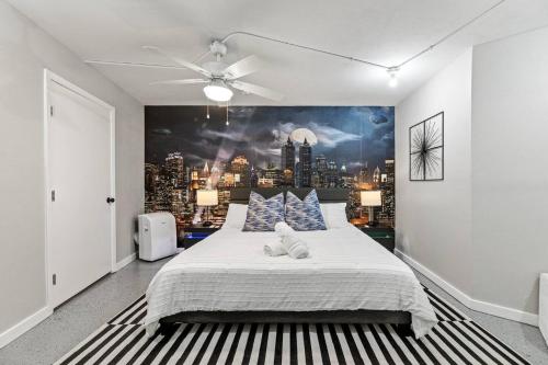 a bedroom with a large bed with a city mural on the wall at Dome Manor 2 Game Rooms, Hot Tub & Pool! in Bedford