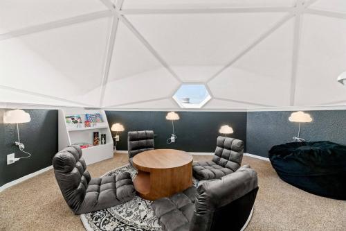 a living room with a table and leather chairs at Dome Manor 2 Game Rooms, Hot Tub & Pool! in Bedford
