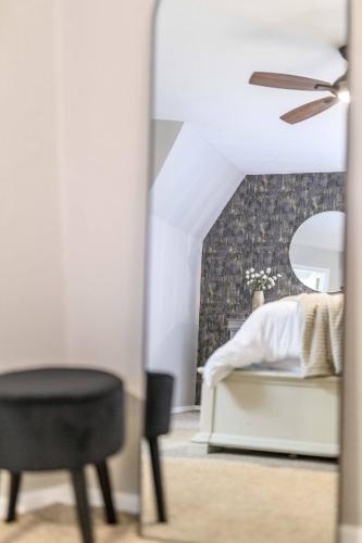 a mirror in a bedroom with a bed and a chair at Dome Manor 2 Game Rooms, Hot Tub & Pool! in Bedford