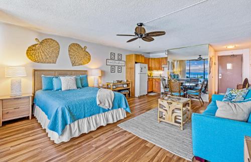ein Schlafzimmer mit Bett und ein Wohnzimmer in der Unterkunft Walkers Paradise Maui at Valley Isle Resort in Lahaina