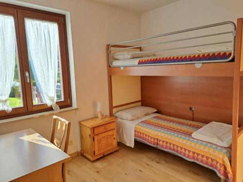 a small bedroom with a bunk bed and a desk at Oasi Pieve in Pian di Scò