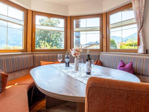 a dining room with a table and windows at Obinghof in Söll