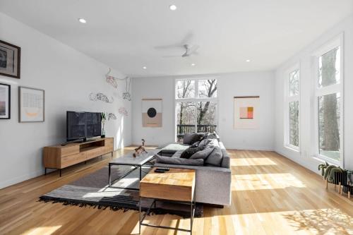 a living room with a couch and a tv at Modern Amenities Downtown - Raleigh Craftsman in Raleigh