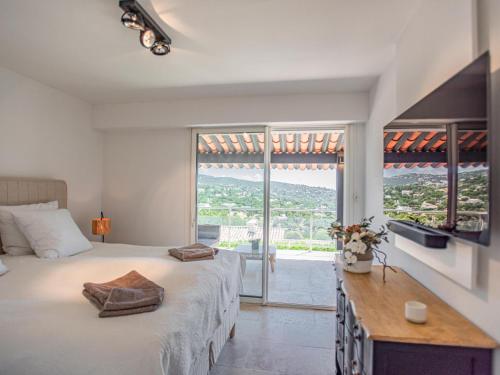 una camera da letto con un letto grande e una grande finestra di Villa les Oiseaux a La Garonnette-Plage