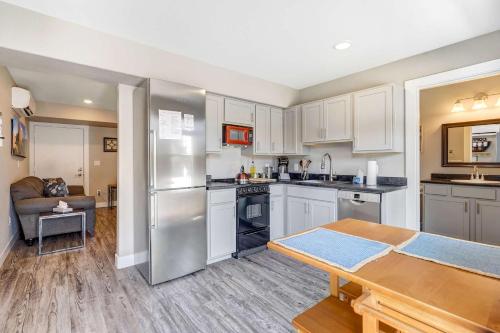 a kitchen with white cabinets and a wooden table at Vermijo Nook Walk to OCC Downtown w Fire Pit in Colorado Springs