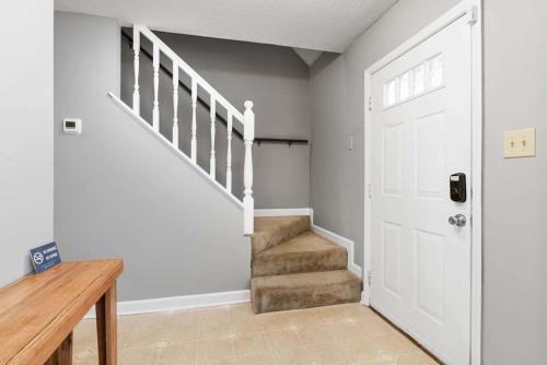 pasillo con escalera y puerta blanca en Near Parks Trails & Downtown Raleigh Retreat, en Raleigh