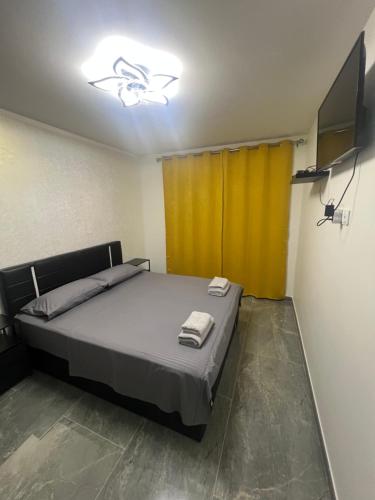 a bedroom with a bed and a yellow curtain at Appartement Luxe & design Vue mer sur la Promenade des Anglais in Nice