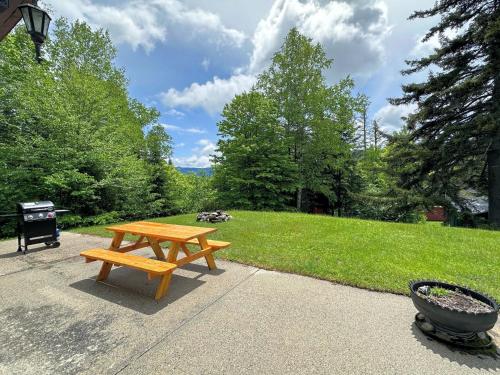 ein hölzerner Picknicktisch auf einem Bürgersteig neben einem Park in der Unterkunft 26CM - private camp in Bretton Woods wifi AC private yard with great views in Carroll