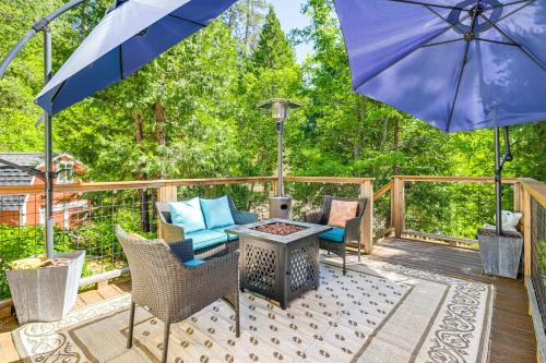 a patio with a blue umbrella and chairs and a table at Peaceful Forest Views and Patio Twain Harte Home in Twain Harte