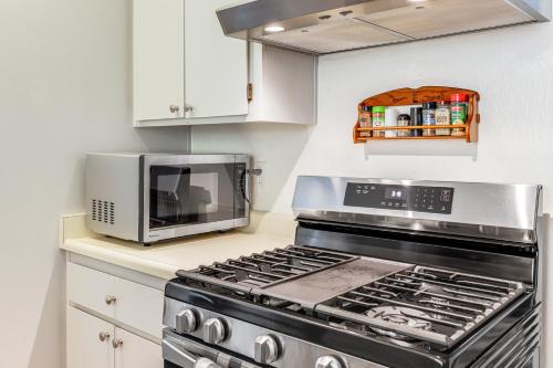 a kitchen with a stove and a microwave at Peaceful Forest Views and Patio Twain Harte Home in Twain Harte