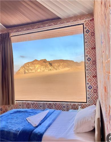 a bedroom with a window with a view of the desert at Rum rose luxury camp in Wadi Rum