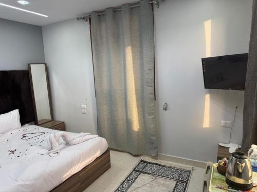 a bedroom with a bed and a television in it at home in the pyramids in Cairo