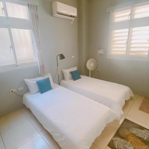 two beds in a room with two windows at 綠島夏御 微熱海岸 in Green Island