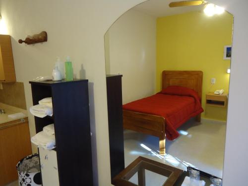 Una pequeña habitación con una cama y un espejo. en Hotel de Campo Posada la Esperanza, en Río Cuarto